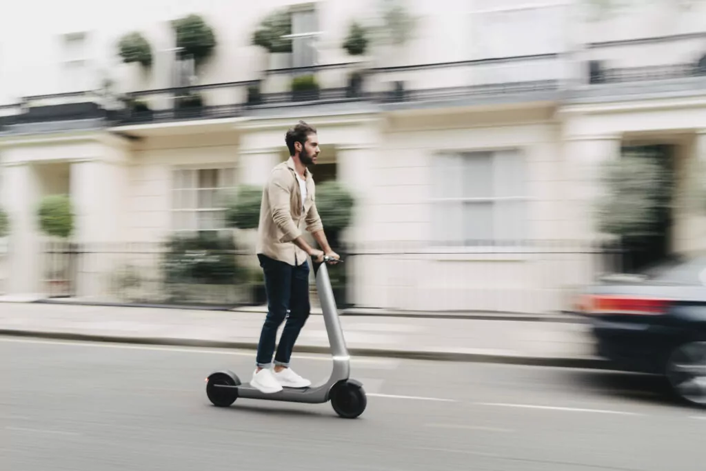 Bo M electric scooter with guy riding down the street