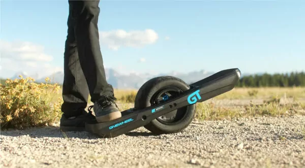 Onewheel GT S series electric self balancing board with blue and black rail guard on gravel