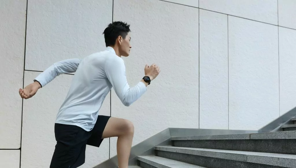 Amazefit GTR 2 sports edition being worn by a male runner climbing steps in an urban area