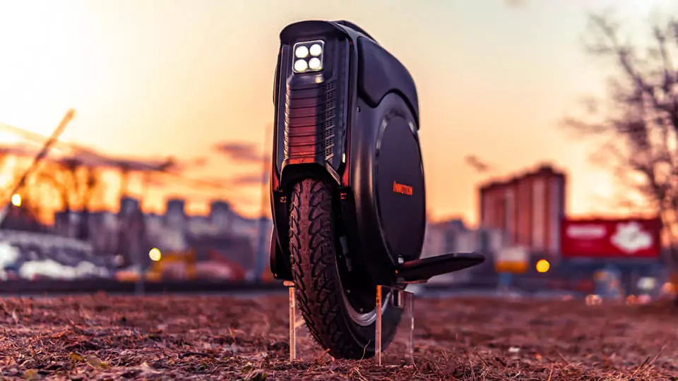 Inmotion V12 Electric Unicycle front side view with city sunset background