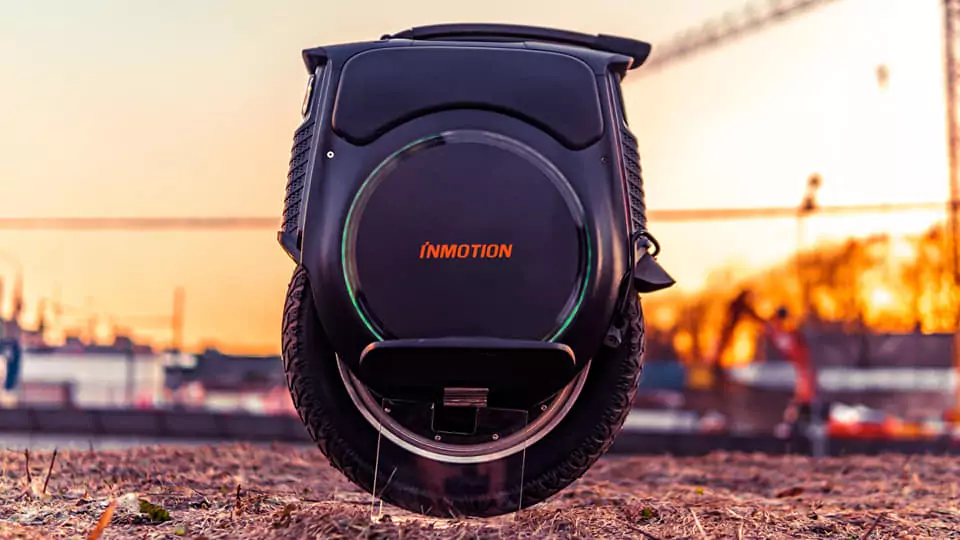 Inmotion V12 Electric Unicycle on a stand from a side view with a sunset background